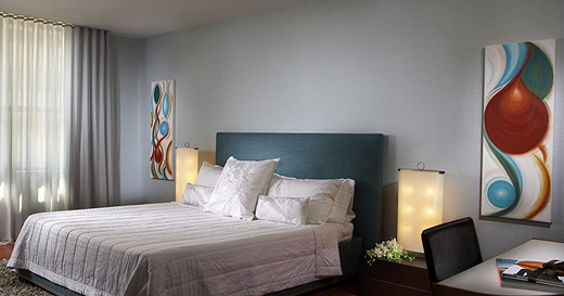 Фото современного дизайна интерьера голубой спальни с абстрактными картинами и светильниками