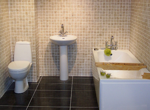 Фото дизайна интерьера ванной комнаты с мелкой светло-коричневой плиткой на стене и чёрным глянцевым полом