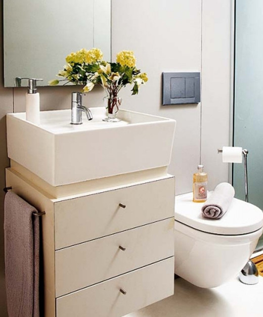 Фото интерьера ванной комнаты с умывальником раковиной со встроенными шкафчиками и ящиками.