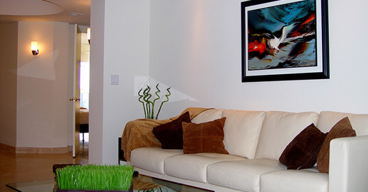 Фотография интерьера мягкого уголка гостиной с белым диваном и современной картиной